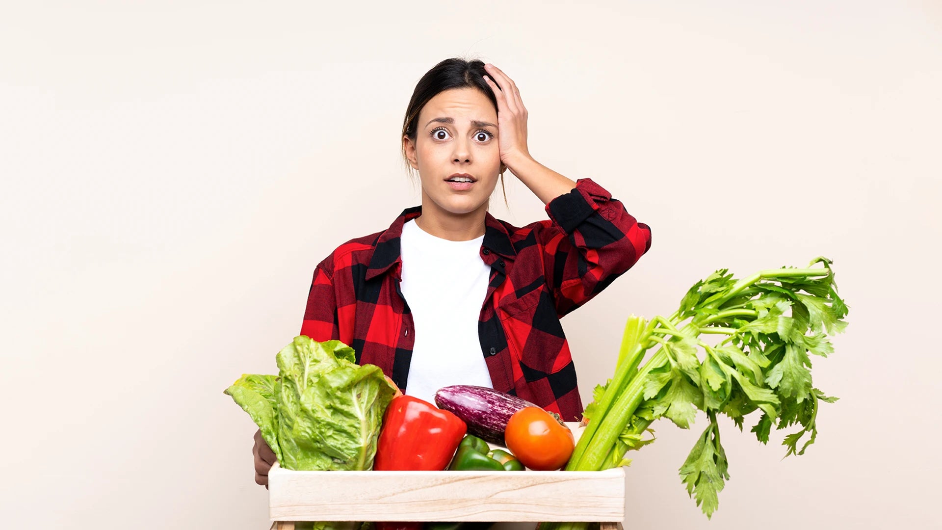 Overwhelmed woman with a box of vegetables